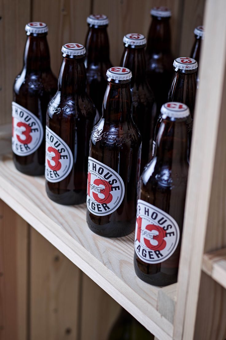 several brown beer bottles are lined up on a shelf