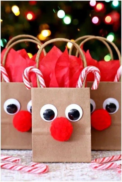 two paper bags decorated like reindeers with candy canes