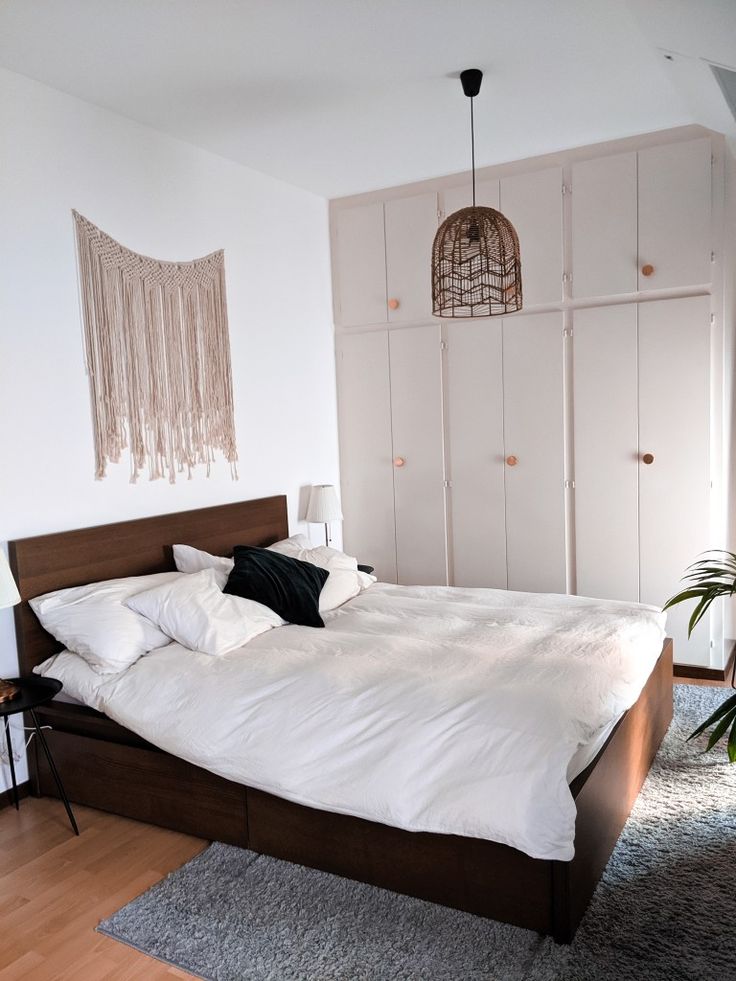 a bed with white sheets and pillows in a room