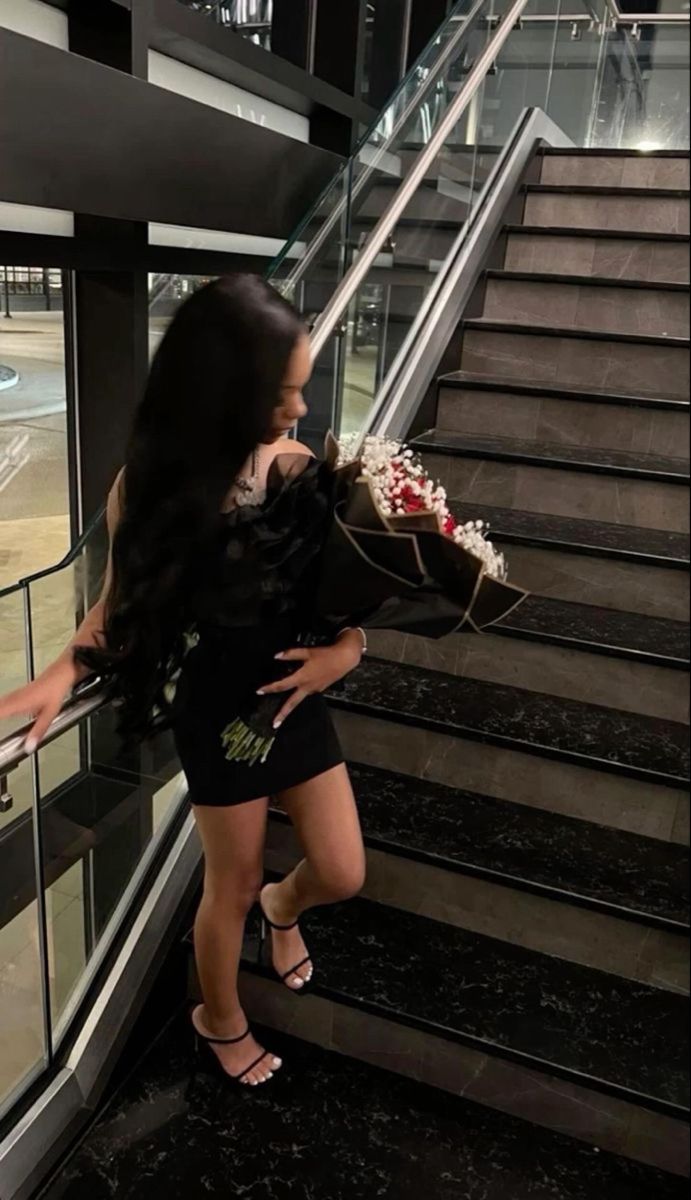 a woman is walking down the stairs with flowers in her hand