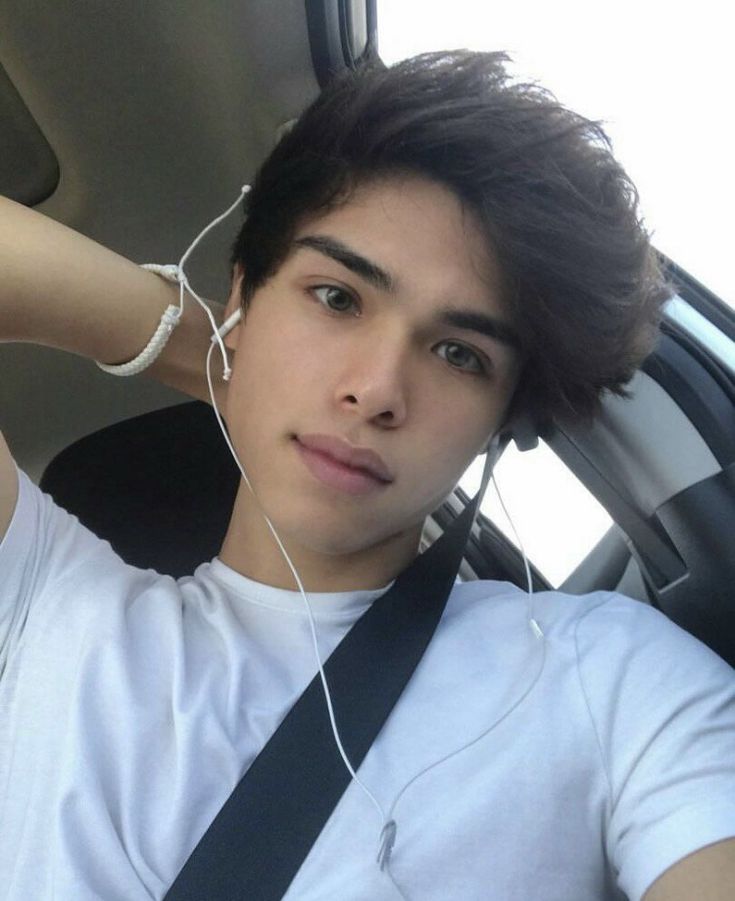 a young man sitting in the back seat of a car wearing headphones