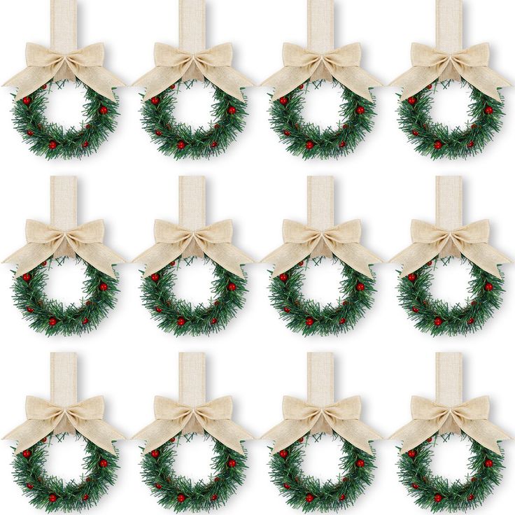 twelve christmas wreaths with bows and berries on them, all tied in burlocks