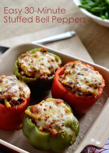 four stuffed bell peppers in a baking dish