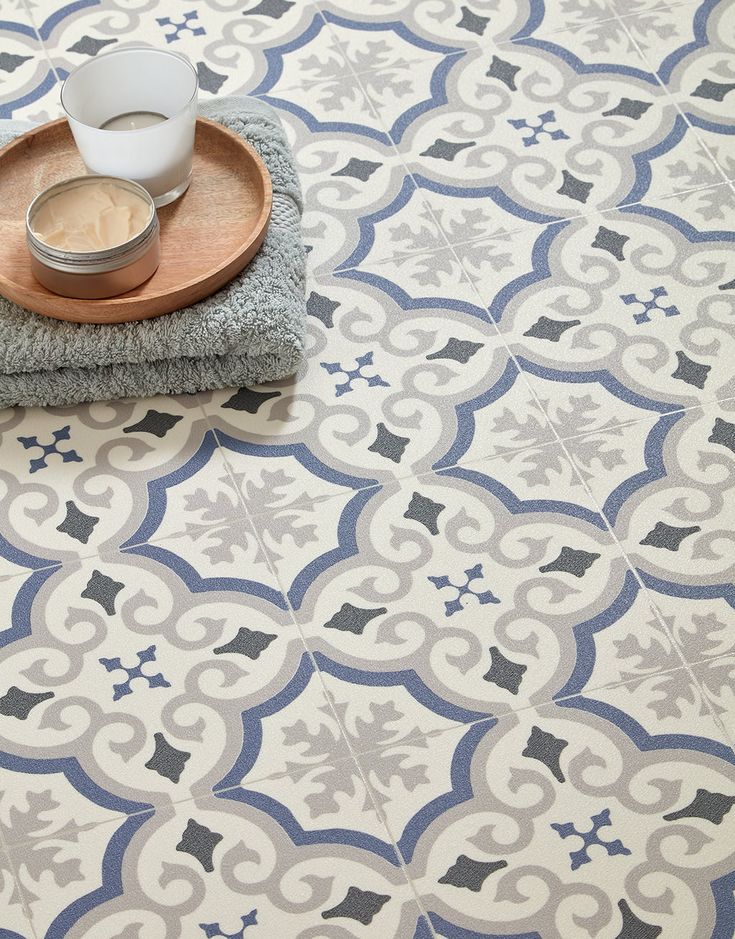 a wooden tray sitting on top of a floor covered in blue and white patterned tiles