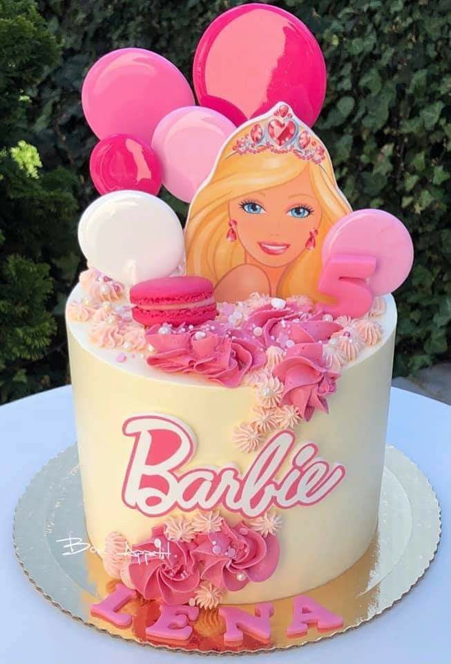 a barbie birthday cake with balloons and decorations