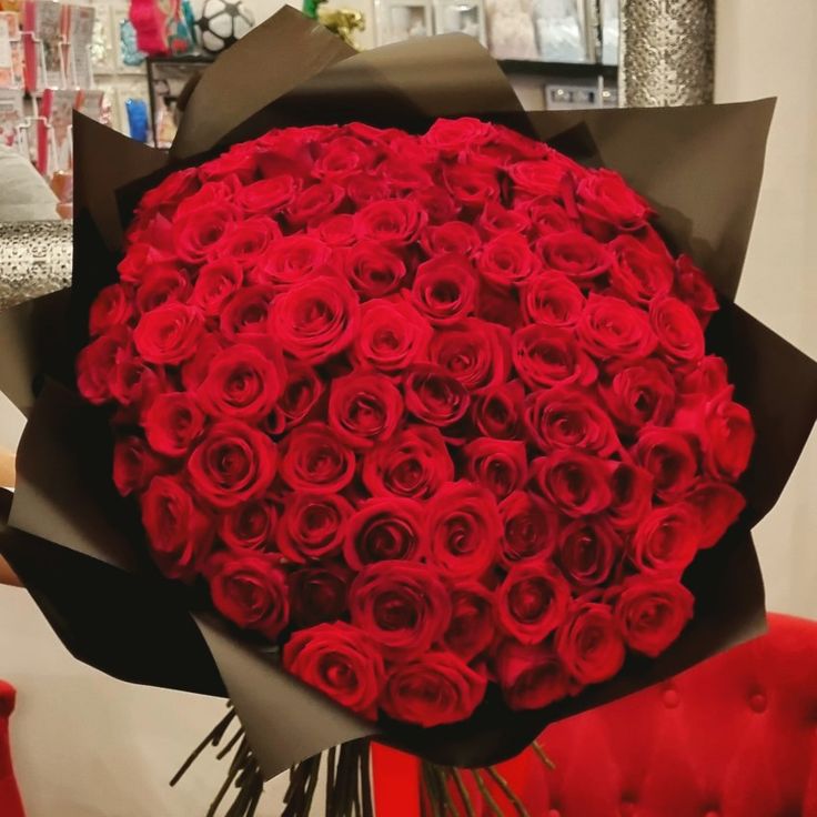 a large bouquet of red roses is sitting on a chair