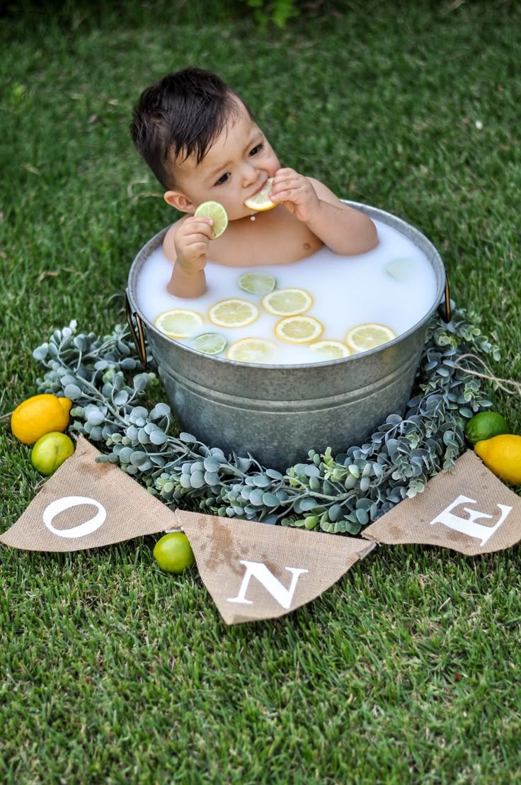 a baby is taking a bath in a tub with lemons