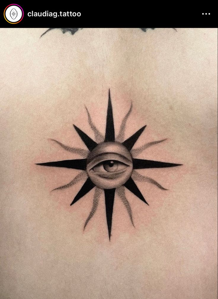 an eye tattoo on the back of a woman's upper body, with black lines