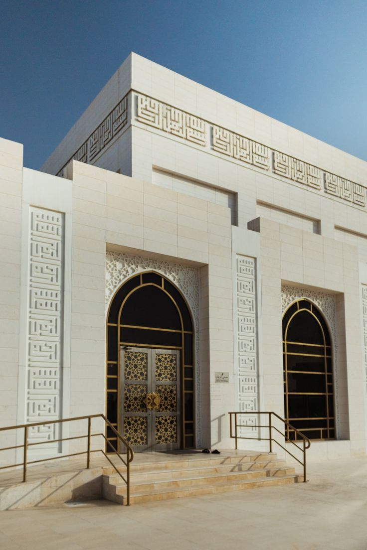 a white building with two doors and some steps