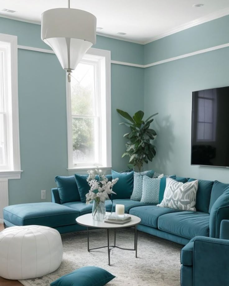 a living room filled with blue couches and pillows on top of a white rug