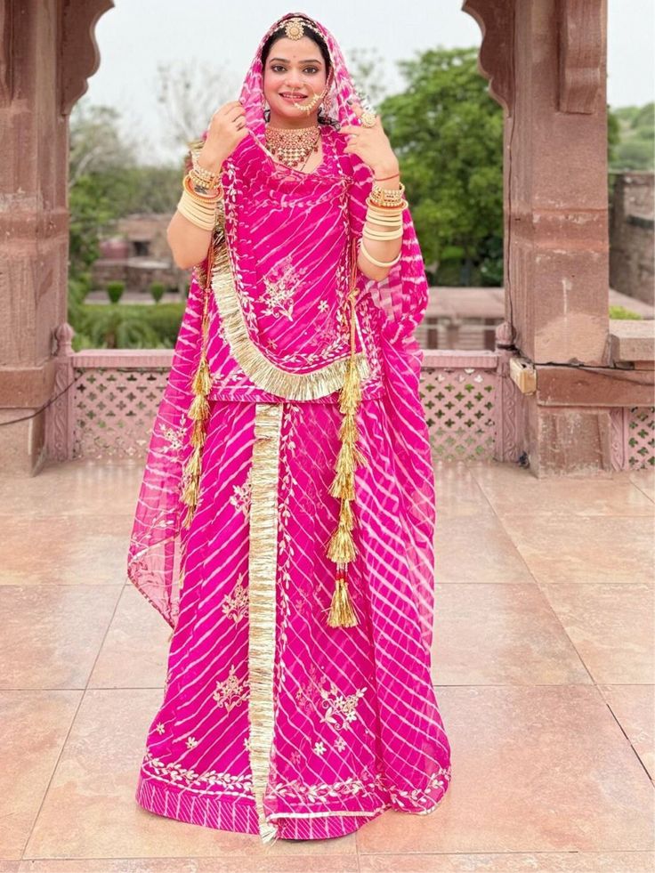 Zari Kasab Leheriya Humrahi Sawan Special Rajputi Poshak In Pink color Product Details: Fabric: Heavy Leheriya Humrahi  Work:  Zari Kasab  Odna me Four Side Border Odhna Fabric: Leheriya Humrahi  Color Family: Pink Style:Rajasthani, Rajputana Occasion:Festive, Traditional,Wedding Washing Instruction:Dry Wash The Semi-stitched Lehenga Waist and Hips are Customizable from 28 to 40 inches and from 32 to 44 inches respectively and Lehenga Length is 42 inches Do note: Accessories shown in the image a Laheriya Design Lahenga, Bandhani Print Dupatta For Diwali, Pink Sharara With Cutdana For Puja, Lehriya Poshak, Pink Cutdana Sharara For Puja, Pink Lehenga With Bandhani Print For Puja, Pink Bandhani Print Choli For Puja, Lehenga Designs Leheriya, Pink Bandhani Print Lehenga For Puja