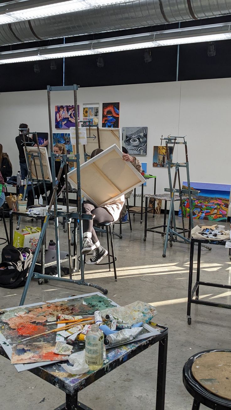 an art studio with easels and paintings on display