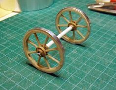 two miniature wheels sitting on top of a green table