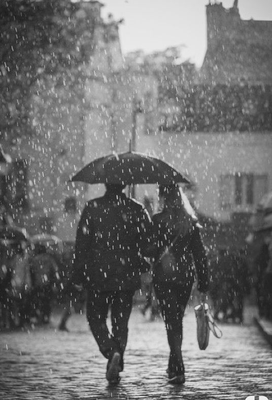 two people walking in the rain with umbrellas