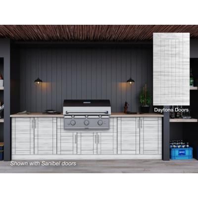 an outdoor kitchen with white cabinets and black walls