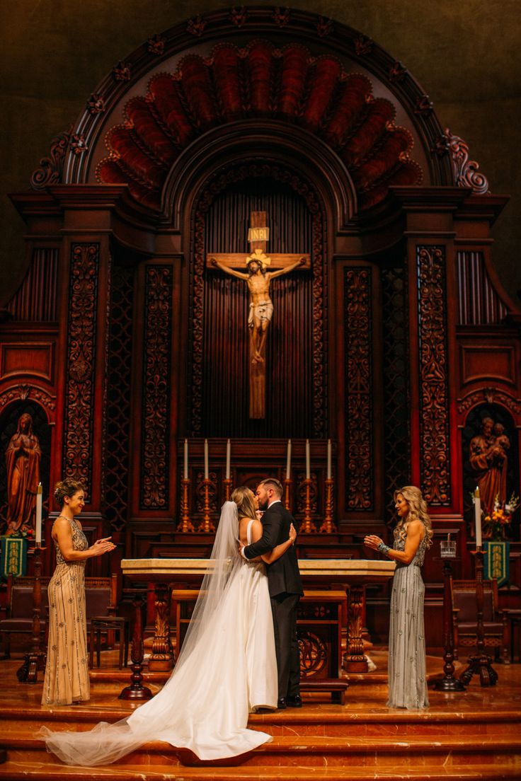 a bride and groom are standing in front of the alter