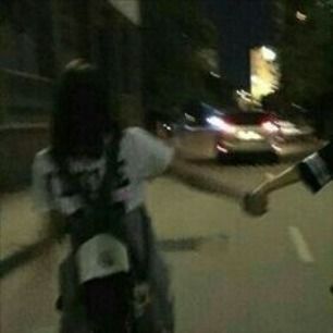 two skateboarders doing tricks on the street at night