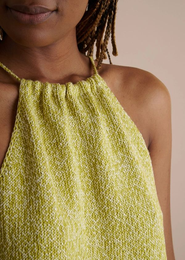 a woman with dreadlocks wearing a yellow top