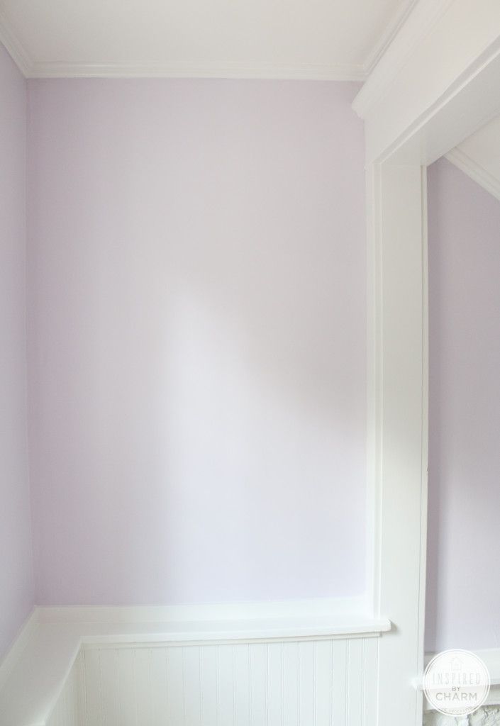 an empty room with purple walls and white trim