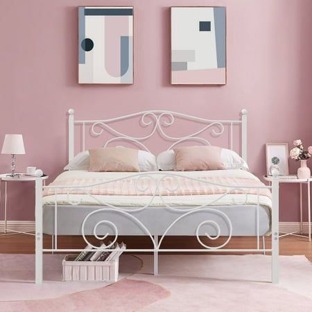 a bedroom with pink walls, white bed and two pictures on the wall above it