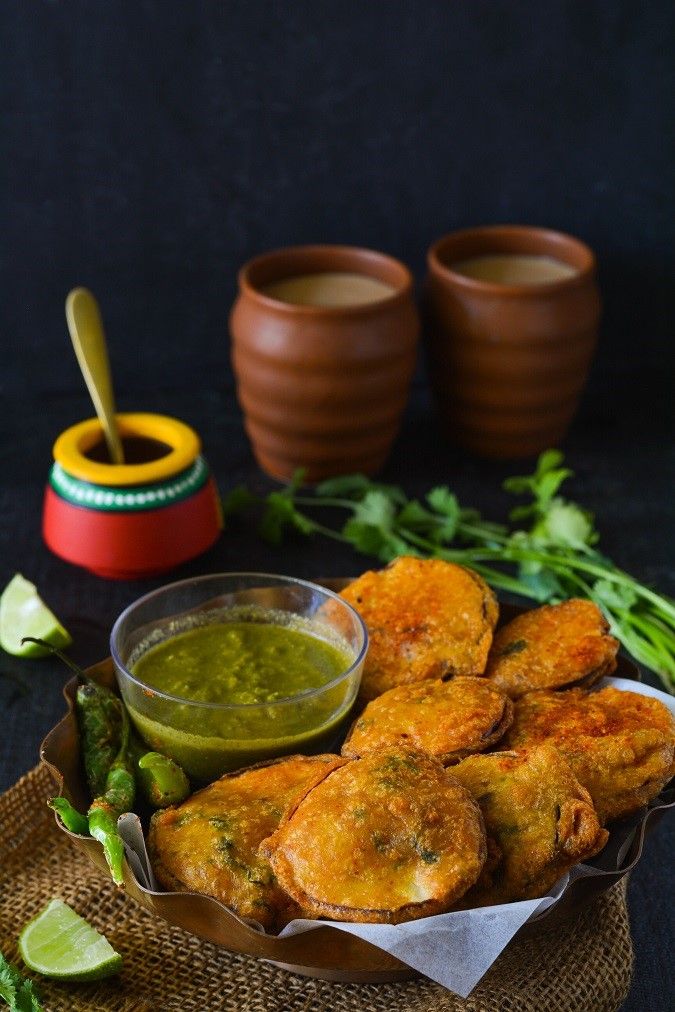 some fried food is on a plate with dipping sauce and green vegetables next to it