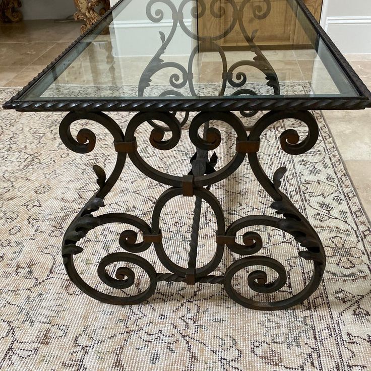 a glass and metal table sitting on top of a rug