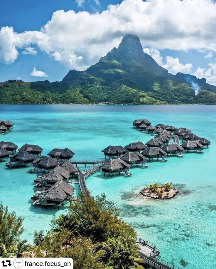 the water is crystal blue and clear with many huts on it