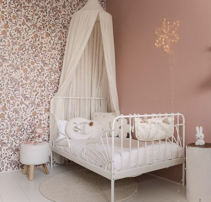 a white bed sitting next to a pink wall