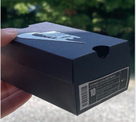 a person holding up a black box with the number ten on it's side