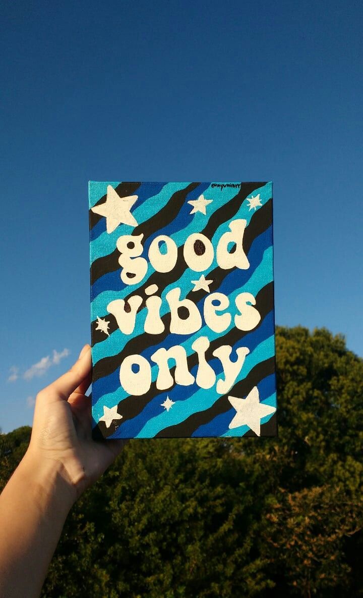 someone holding up a card with the words good vibes only written in white on it