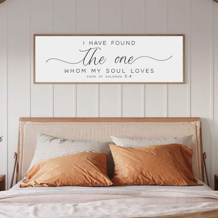 a bed with two pillows and a sign above it that says i have found the one whom my soul loves