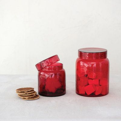 two red jars filled with cookies next to each other