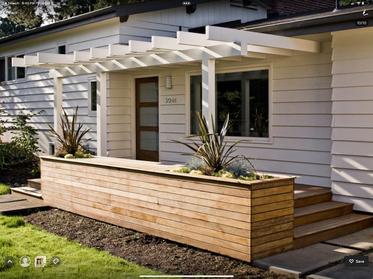 a wooden planter sitting on the side of a house