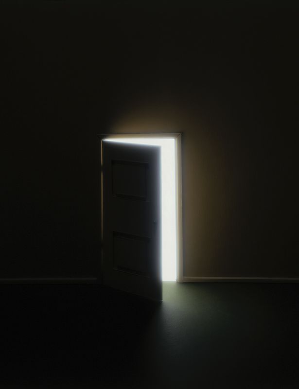 an open door in a dark room with light coming through the opening to reveal it