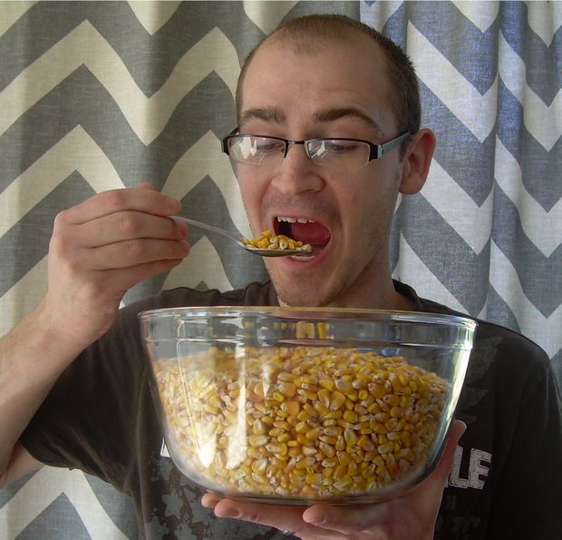 a man is eating corn from a bowl