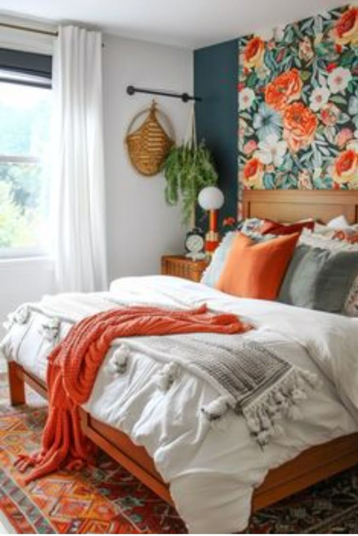 a bedroom with floral wallpaper and orange accents