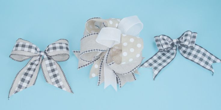 three bows with white and black checkered fabric on blue background, one is tied to the side