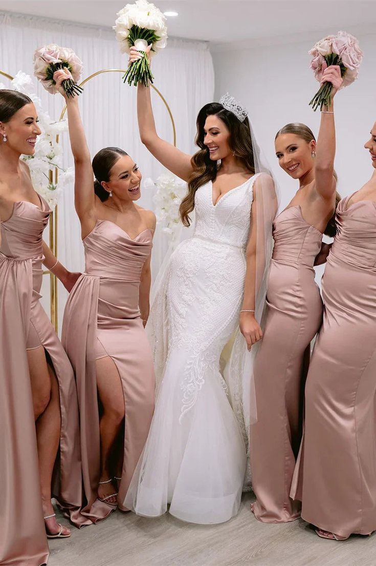 a group of women standing next to each other holding bouquets in front of them