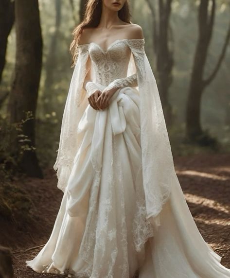 a woman in a white wedding dress standing on a forest path with her arms wrapped around her waist