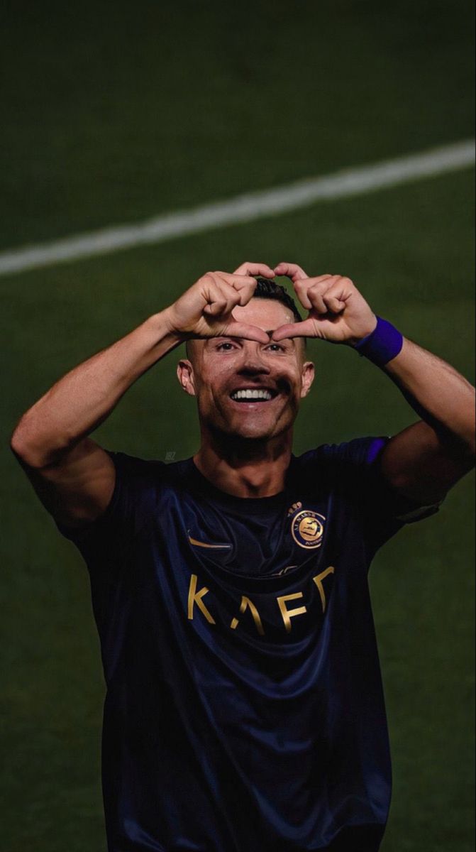 a soccer player is making a funny face while holding his hands up to his head