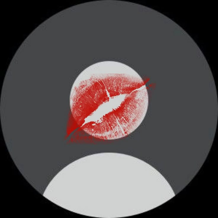 a black and white circle with a red lip on the center, in front of a dark background