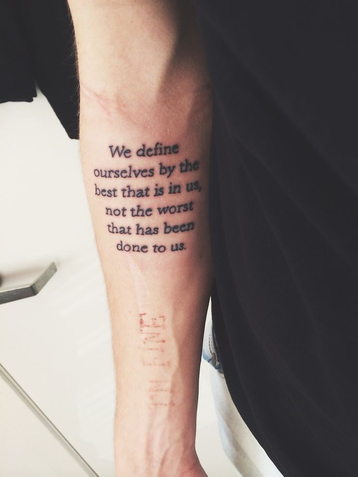 a person with a tattoo on their arm saying we defined ourselves by the best that is in us, not the worst that has been done to us