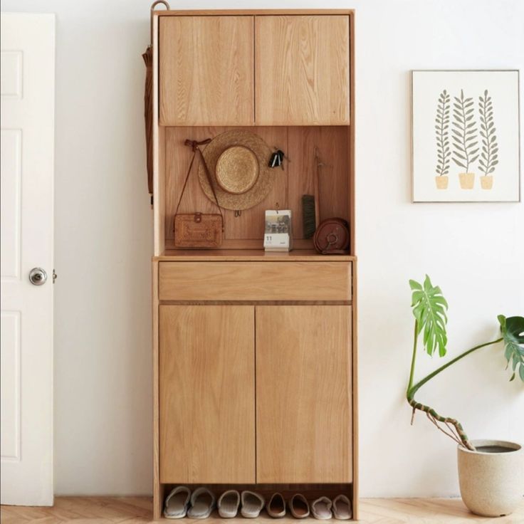 a wooden cabinet sitting next to a potted plant