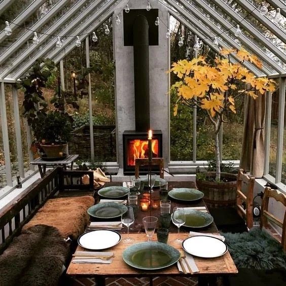 a dining room table with plates and place settings in front of an open fire place