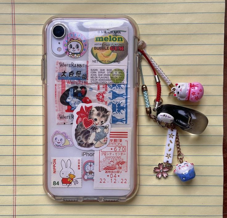 an iphone case with many stickers on it and a keychain attached to the back