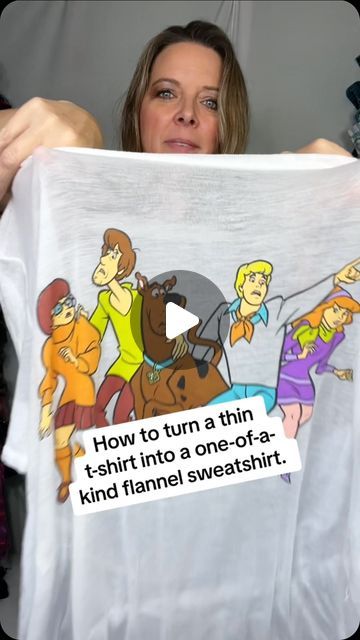 a woman holding up a t - shirt with cartoon characters on it