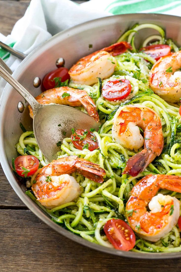 a pan filled with shrimp and pesto pasta