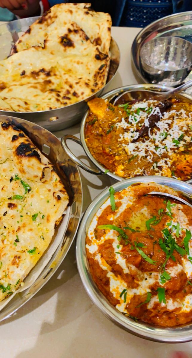 several different types of food are sitting on a white tablecloth covered table with utensils