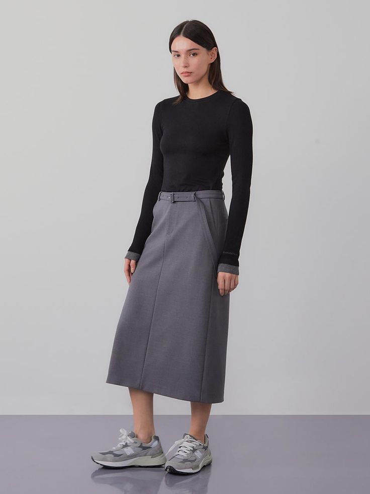 This product is a belted long skirt that exudes sophistication and modern style. The high-waisted design is accentuated with a belt, offering both elegance and a flattering fit. - The skirt features a sleek, straight cut that falls to mid-calf, providing a streamlined silhouette.- A built-in belt cinches at the waist, enhancing the skirt’s tailored appearance.- Made from a smooth, structured fabric, the skirt holds its shape while allowing for ease of movement.- Perfect for professional settings or dressy occasions, this skirt pairs effortlessly with both fitted and loose tops. Midi Length Skirt With Belt Loops, Elegant Relaxed Skirt With Belt, Elegant Belted Skirt For Spring, Elegant Spring Skirt With Belt Detail, Elegant Skirt With Belt, Relaxed Fit Belted Flared Skirt, Formal Fitted Skirt With Belt Detail, Belted Relaxed Midi Skirt, Belted Asymmetrical Skirt For Workwear