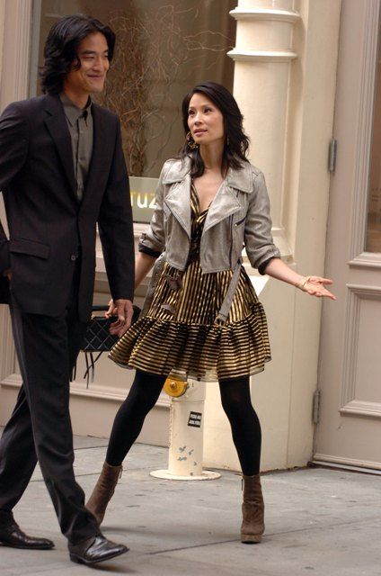 a man and woman are walking down the street holding their hands out to each other